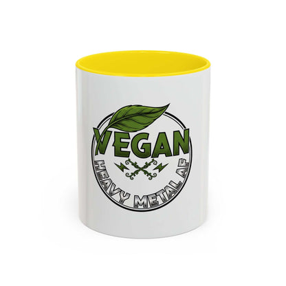Glossy ceramic mug with Vegan Heavy Metal Logo featuring leafy green text and crossed lightning bolts on white background with colored handle and interior